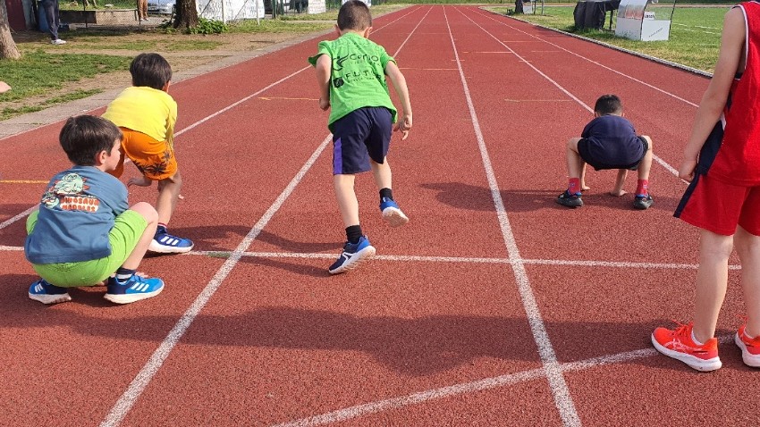 Bambini che giocano con coni e ostacolini in pista
